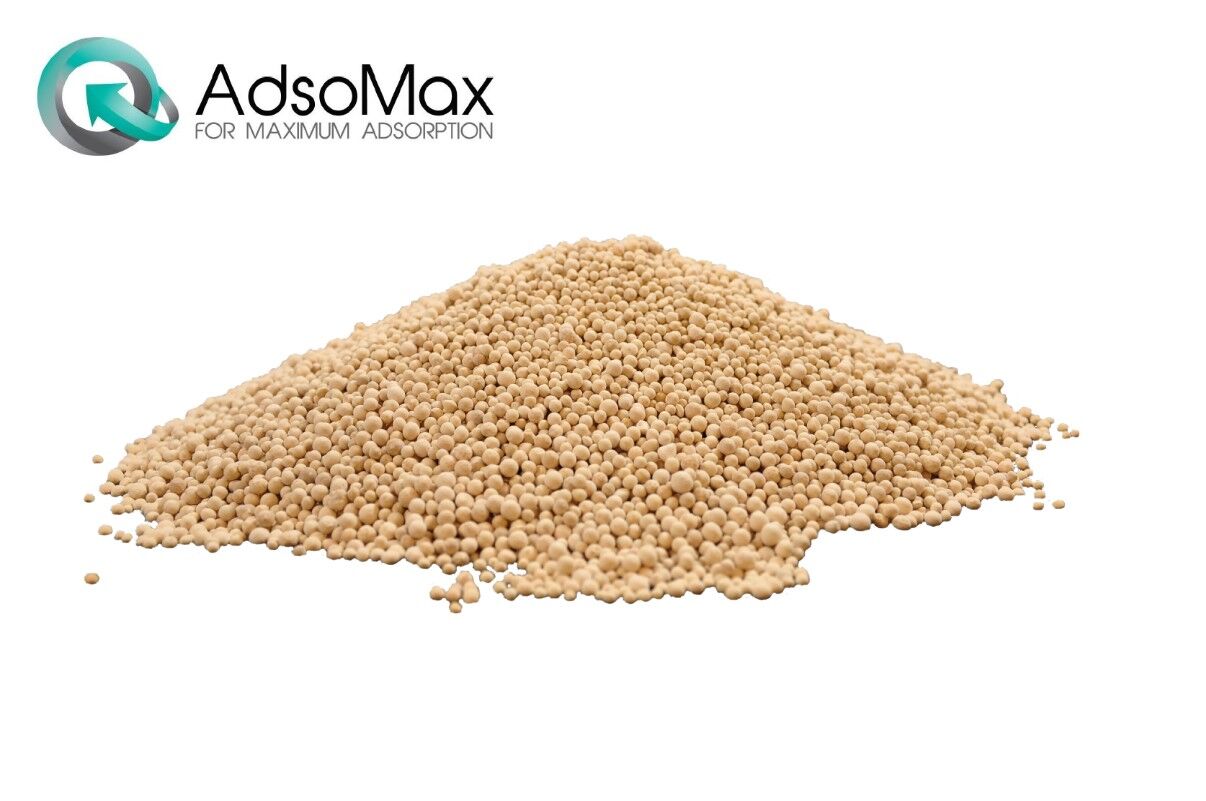 En hög med beige adsomax adsorbentpärlor på vit bakgrund med en företagslogotyp i det övre vänstra hörnet.
