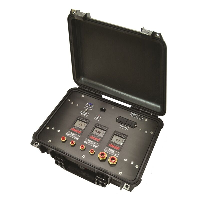 Ett öppet, robust fodral som innehåller elektronisk testutrustning med olika rattar och kontakter.